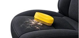 Pet hair removal brush on a fabric vehicle seat